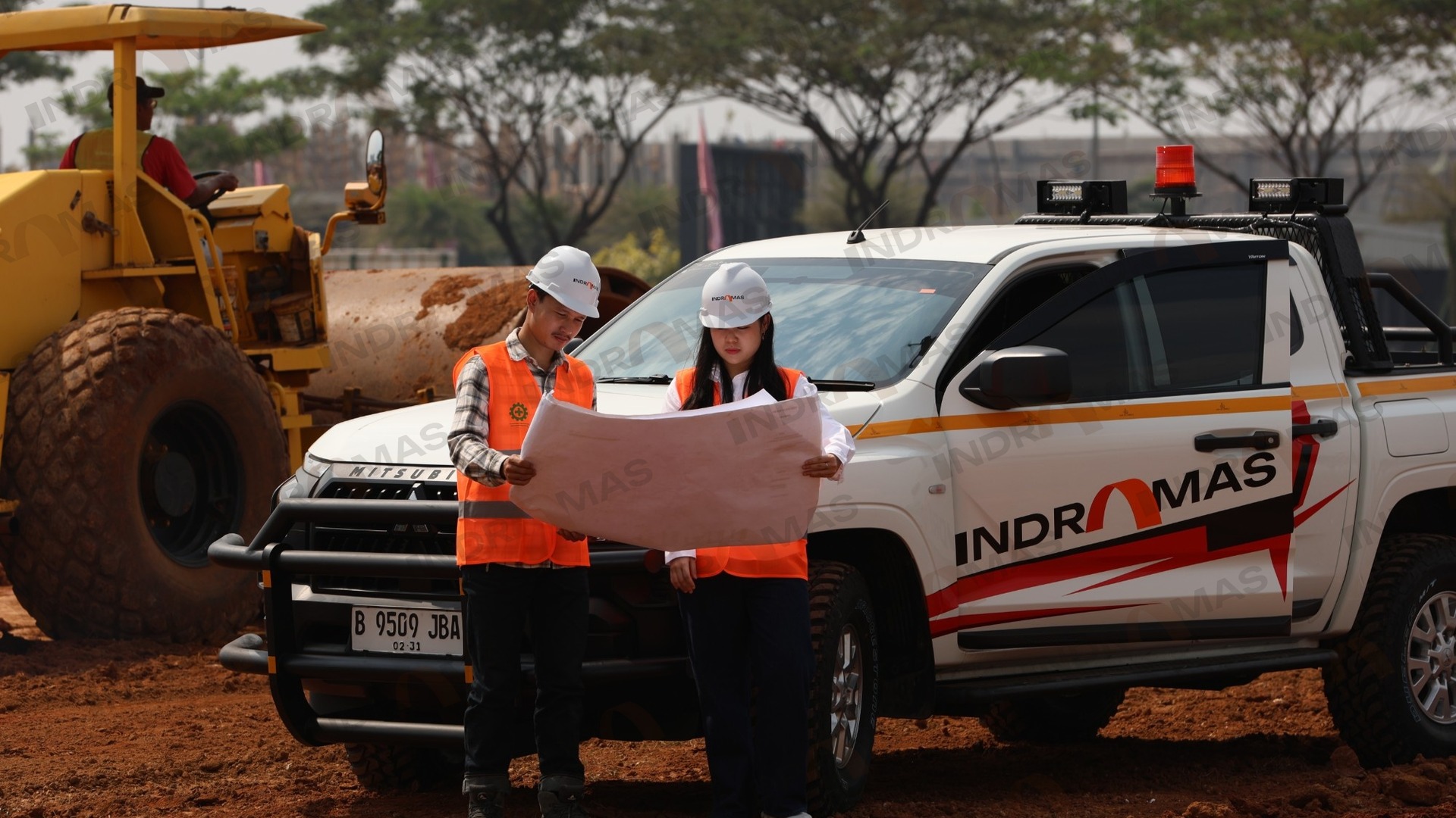 Indramas engineers reviewing drawings on site beside a company vehicle